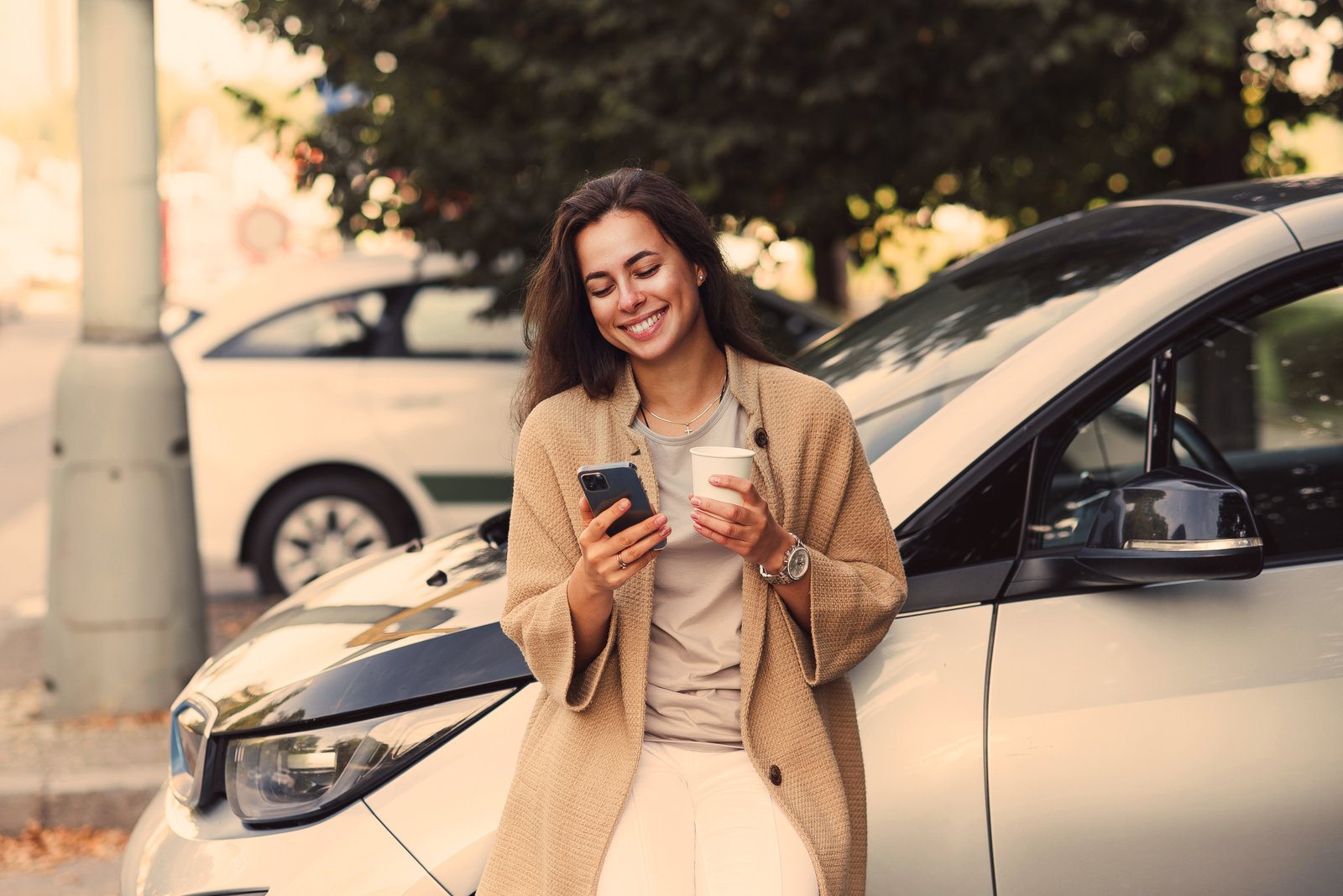 AdobeStock_457934968_Frau im Auto mit Smartphone
